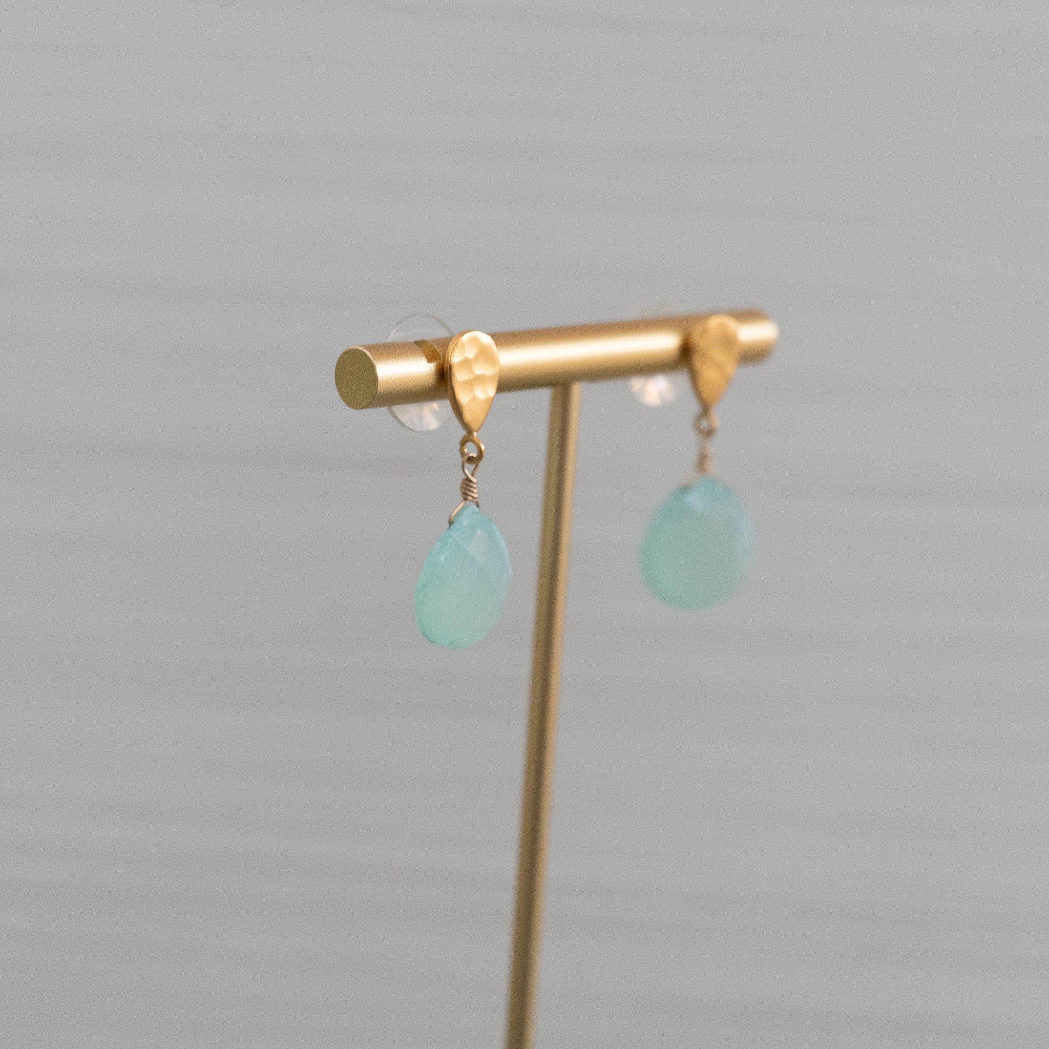 matte gold hammered stud earrings with large blue gemstones handmade in Hawaii by eve black jewelry  Edit alt text