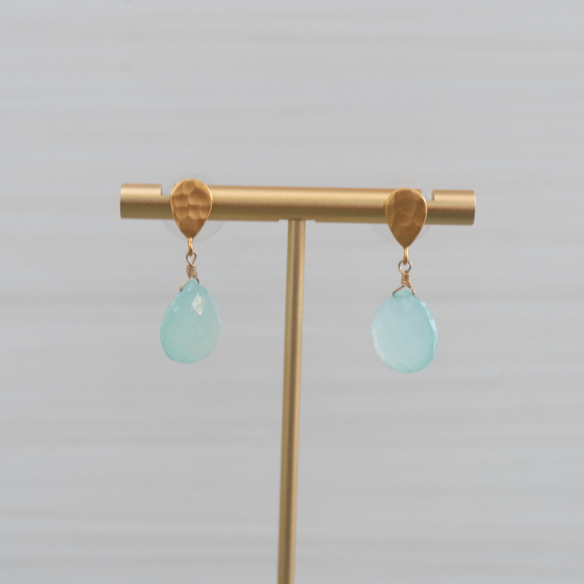 matte gold hammered stud earrings with large blue gemstones handmade in Hawaii by eve black jewelry