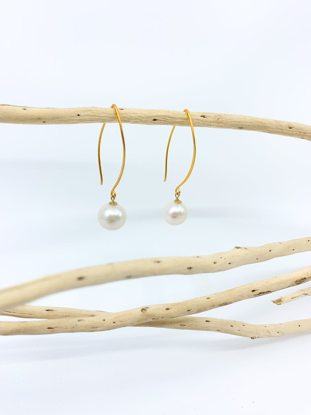 white pearl earrings with long mat gold hook by eve black jewelry made in Hawaii